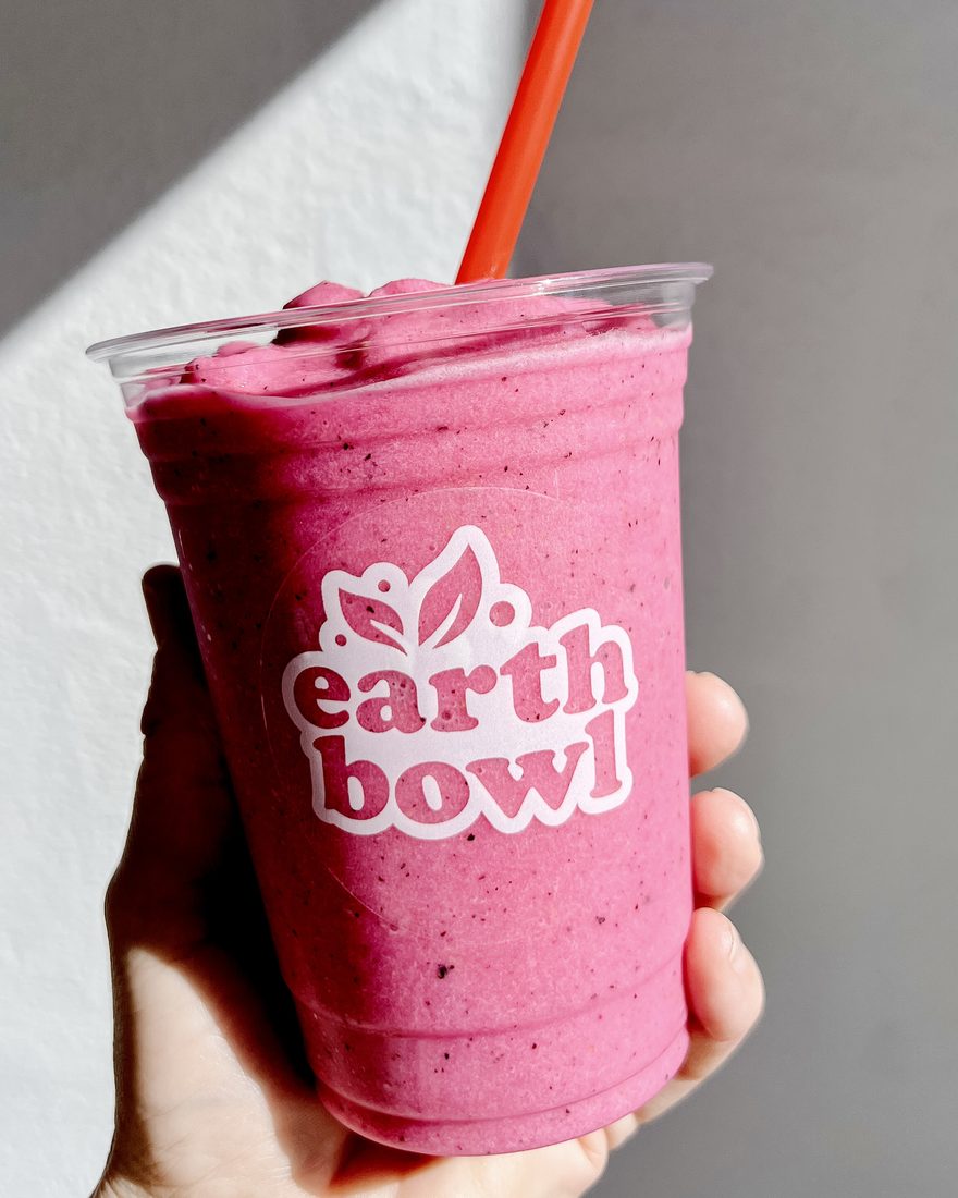A pink Earth Bowl smoothie in a branded cup